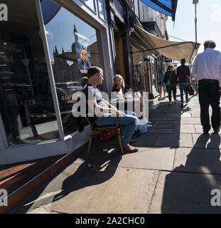 Zwei Leute saßen am Bürgersteig Tabelle Gespräch bei einem Kaffee Könige parade Cambridge 2019 Stockfoto