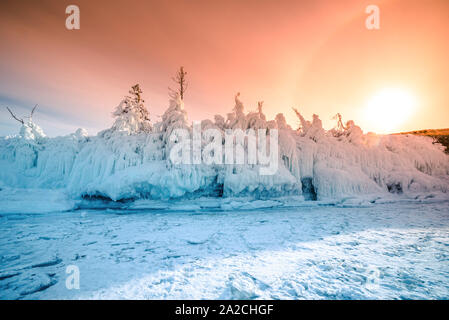 Baum, bedeckt mit Eis und Schnee bei Sonnenuntergang in den Ufer der hochfliegenden Baikalsee im Winter, Sibirien, Russland. Stockfoto