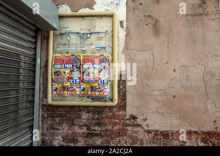 Alten zerrissenen Poster Förderung ein Karneval in die Stadt kommen. Auf alten Ziegelmauer mit abblätternder Farbe. Tipton, nordwestlich von Birmingham, West Midlands, UK. Stockfoto