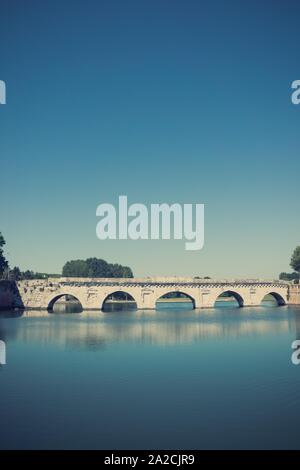 Vertikale Foto von sehr alten alten Brücke in italienischer Stadt Ponte di Tiberio. Die Brücke über den Fluss mit blauen Wasser gebaut. Im Sommer Himmel ist Blu Stockfoto