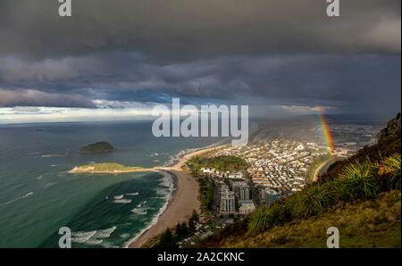 Blick auf den Mount Manganui Bezirk und Tauranga Hafen, Blick vom Mount Maunganui mit Regenbogen, Bay of Plenty, North Island, Neuseeland Stockfoto