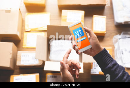 Online shopping Konzepte mit youngman mit Smartphone für die Zahlung seine Bestellung auf einer Menge Produkt Paket. Ecommerce Markt. Business retail. Moderne Stockfoto