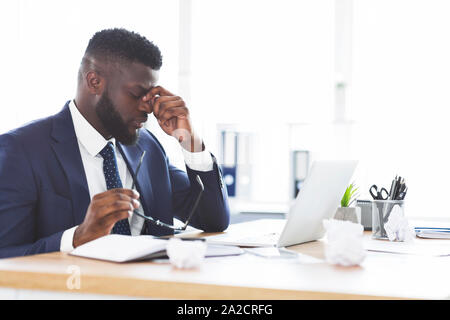 Müde afrikanische amerikanische Geschäftsmann seine Brille abnehmen Stockfoto