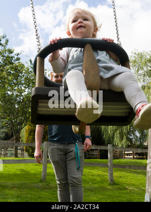 Vater, Tochter auf einer Schaukel, Großbritannien Stockfoto