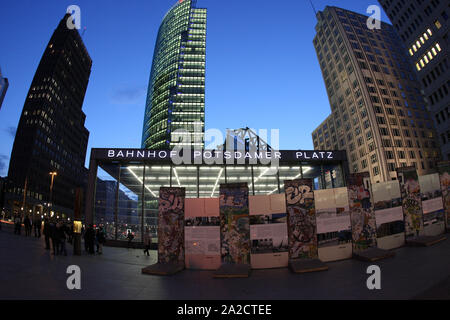 Bild der U-Bahn-Haltestelle Potsdamer Platz in Berlin während der blauen Stunde mit antiken Stücken der ursprünglichen Berliner Mauer im Vordergrund Stockfoto