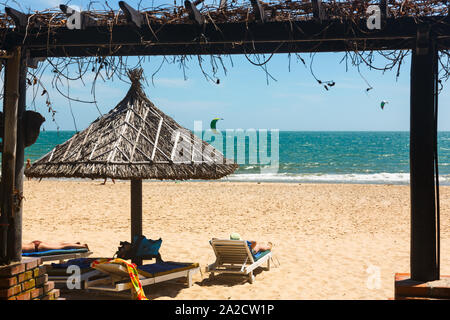 MUINE, VIETNAM - Januar 31, 2014: Sonnenliegen und Sonnenschirm am Strand in Vietnam. Stockfoto