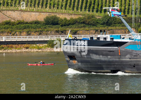 Frachtschiff auf dem Rhein, einem kleinen Kajak Sport Boot überholt, Deutschland Stockfoto