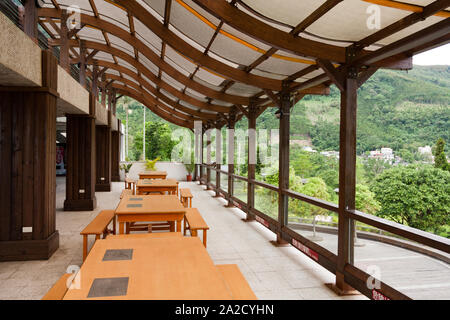 Terrasse mit Tischen und Bänken, Holzbalken Dachstuhl mit S-Kurve Form, mit Polycarbonat Blatt abgedeckt, Hualien Taiwan Stockfoto