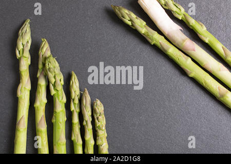 Auswahl an frischen Spargel auf schwarzem Schiefer mit Textfreiraum Stockfoto