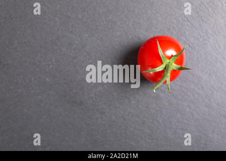 frische reife Tomaten auf schwarzem Schiefer Stockfoto