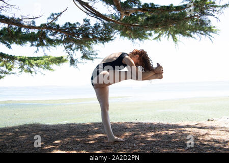 Frau Yoga am Meer, Bainbridge Island, Washington State, USA Stockfoto