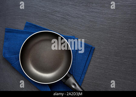 Leere Pfanne über dunklen grauen Stein Hintergrund. Ansicht von oben Stockfoto