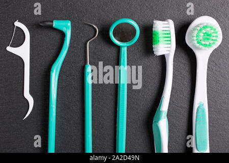 Auswahl der Zahnarzt Pinsel und Werkzeuge auf eine schwarze Schieferoberfläche Stockfoto