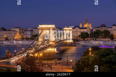 Kettenbrücke in Budapest, Ungarn. Donau mit Booten. Am Abend wird der Verkehr mit leichten Wanderwegen. Stockfoto