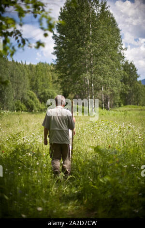 Ältere Menschen wandern durch eine Wiese Stockfoto
