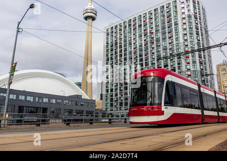 Die TTC (Toronto Transit Commission) Straßenbahn fährt am Rogers Centre und dem CN Tower in der Innenstadt von Toronto vorbei. Stockfoto