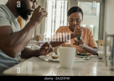 Junge afrikanische amerikanische Paar zu Hause Frühstücken sitzen Stockfoto