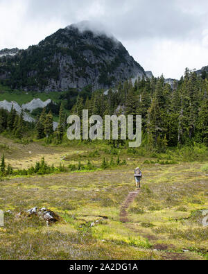 Ein Mann Wanderungen entlang einer Spur für ein Wochenende in die Berge. Stockfoto