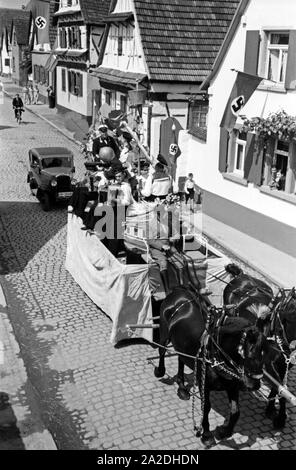 Pferdefuhrwerke im Festzug zum Rettichfest in Schifferstadt, Deutschland, 1930er Jahre. Pferdekutschen am Pageant der jährlichen Rettich Messe in Schifferstadt, Deutschland 1930. Stockfoto