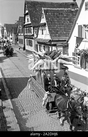 Pferdefuhrwerke im Festzug zum Rettichfest in Schifferstadt, Deutschland, 1930er Jahre. Pferdekutschen am Pageant der jährlichen Rettich Messe in Schifferstadt, Deutschland 1930. Stockfoto