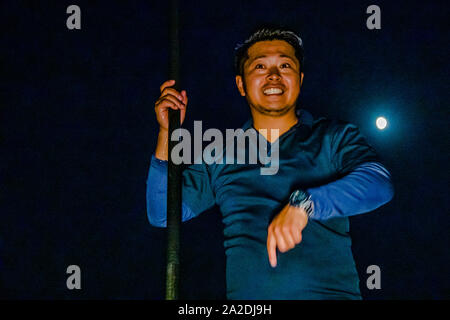Takiya-ryo Speerfischen auf dem See Hanama, Hamamatsu, Japan. Ikuya Yamamoto erklärt, wie man den Speer hält und dass der Speer mit großer Entschlossenheit geführt werden sollte. Der Vollmond schaut über seine Schulter Stockfoto
