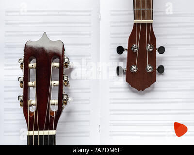 Gitarre und Ukulele. Holz- Instrumente. Hawaiian guitar. Leichte Musik. Notizen und Streichern. Akustische Instrumente. Gitarre Griffbrett. Nylonsaiten. Stockfoto