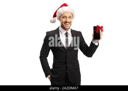 Fröhlicher Mann in Anzug und einem Weihnachtsmann Mütze mit Handy für ein Geschenk auf weißem Hintergrund Stockfoto