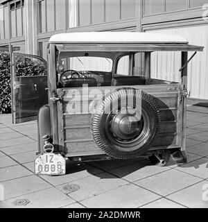 Ein Ford V8 Modell 68 mit Holzverkeidung der Firmenzentrale der Ford Werke in Köln Niehl, Deutschland 1930er Jahre. Ein Ford V8-Modell 68 mit Holz Folien vor der Deutschen Ford Zentrale in Köln, Deutschland 1930. Stockfoto