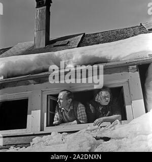 Eine Frau und ein Mann Schulmeisterschaft aus ihrem Dachfenstern, Deutschland 1930er Jahre. Ein Mann und eine Frau, die von Ihrem Dach Fenster, Deutschland 1930. Stockfoto