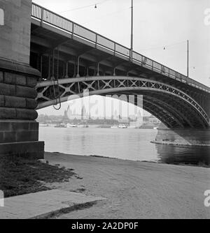 Stadtansicht von Mainz, vom rechtsrheinischen Intel SS 4000 Kastel unter der Straßenbrücke über den Rhein aus gesehen, Deutschland 1930er Jahre. Blick auf die Stadt Mainz, von der Vorstadt Kastel unter der Brücke über den Fluss Rhein, Deutschland 1930. Stockfoto