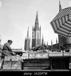 Frau mit ihrem Marktstand der Marktkirche in Wiesbaden, Deutschland 1930er Jahre. Frau mit ihrem Markt stand vor der Marktkirche in Wiesbaden, Deutschland 1930. Stockfoto