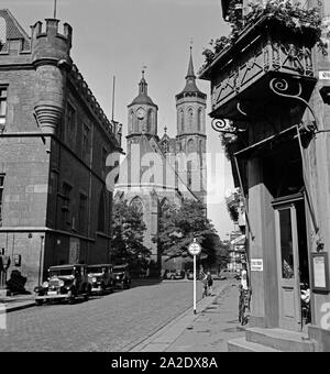 Blick auf die Johanniskirche in Göttingen, vorbei am Rathaus und bin Blumengeschäft Scheuermann, Deutschland 1930er Jahre. Anzeigen neben dem Rathaus und dem blumenladen Scheuermann zu te St. John's Church in Göttingen, Deutschland 1930. Stockfoto