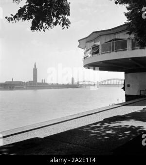 Blick von der Bastei südwärts in die Hohenzollernbrücke und die Messehallen mit Messeturm in Köln, 1930er Jahre. Blick von der Bastei nach Süden zu Hohenzollernbruecke und faire Gebäude mit Turm, Köln 1930. Stockfoto