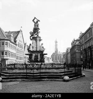 Der herkulesbrunnen und im Hintergrund sterben Ulrichskirchen in Augsburg, Deutschland 1930er Jahre. Hercules Brunnen und die Kirche St. Ulrich in Augsburg, Deutschland 1930. Stockfoto