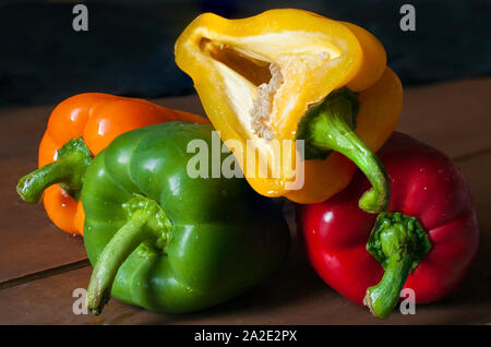 Frische Paprika, rot, orange grün und gelb in einer Makrofotografie mit schlechten Lichtverhältnissen Stockfoto