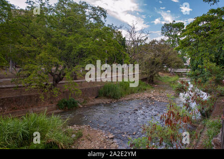 Die Cali Fluss fließt durch das Zentrum der Stadt Cali in Kolumbien. Der Parque Simón Bolivar grenzt an die Böschung. Stockfoto