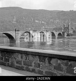 Blick vom gegenüberliegenden Neckarufer in die Alte Brücke und das Schloß von Heidelberg, Deutschland 1930er Jahre. Ansicht vom gegenüberliegenden Ufer von Rover Neckar auf die Alte Brücke und das Schloss von Heidelberg, Deutschland 1930. Stockfoto