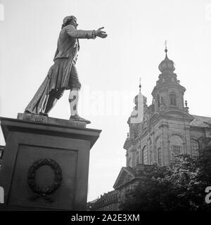 Das schillerdenkmal vor dem Theater in Mannheim mit Denbeiden Türmen der Jesuitenkirche St. Igantius und Franz Xaver, Deutschland 1930er Jahre. Schiller Denkmal vor dem Theater mit den zwei Glockentürme von St. Ignatius und Franz Xaver in Mannheim, Deutschland 1930. Stockfoto