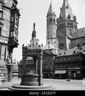 Der Hohe Dom zu Mainz mit Marktplatz, Marktbrunnen und Geschäften am Dom, Deutschland 1930er Jahre. Mainzer Dom mit den wichtigsten Markt, Brunnen und Geschäfte, Deutschland 1930. Stockfoto