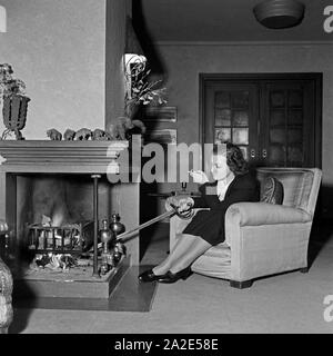 Die schwedische Fictitious character und Sängerin Zarah Leander am Kamin in ihrem Haus in Berlin, Deutschland, 1930er Jahre. Schwedische Sängerin und Schauspielerin Zarah Leander am Kamin in Ihrem Haus in Berlin, Deutschland 1930. Stockfoto