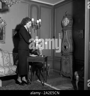 Die schwedische Fictitious character und Sängerin Zarah Leander richtet einen Blumenstrauß in ihrem Haus in Berlin, Deutschland, 1930er Jahre. Schwedische Sängerin und Schauspielerin Zarah Leander Kontrolle eine Blume bouqet in Ihrem Haus in Berlin, Deutschland 1930. Stockfoto