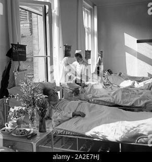 Eine Krankenschwester kümmet sich um kranke Frauen im Mütterheim Dresden in Schloß Dittersbach, Deutschland 1930er Jahre. Eine Krankenschwester Pflege für kranke Frauen an den Rest Zentrum für Mütter in Dittersbach Castle in der Nähe von Dresden, Deutschland 1930. Stockfoto
