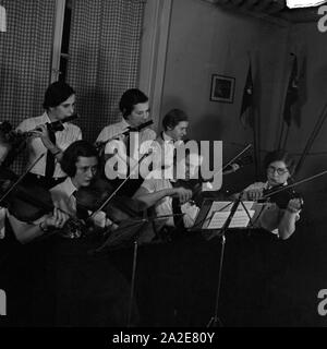 BdM-Mädchen spielen in einem Orchester bei einem Musik- und Heimatabend in Berlin Pankow, Deutschland 1930er Jahre. BdM-Mädchen spielen Musik in einem Orchester in Berlin Pankow, Deutschland 1930. Stockfoto