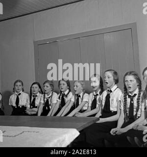 BdM-Mädchen singen Fahrtenlieder in Berlin Pankow, Deutschland 1930er Jahre. BdM-Mädchen singen einige folklore songs in Berlin Pankow, Deutschland 1930. Stockfoto