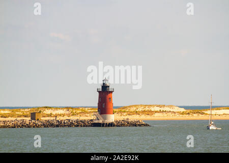 Delaware Wellenbrecher East End Lighthouse und Segelboot vor der Küste von Lewes, Delaware in Lewes. Stockfoto