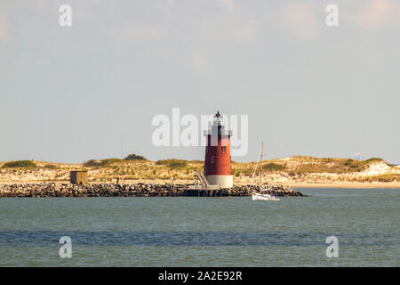 Delaware Wellenbrecher East End Lighthouse und Segelboot vor der Küste von Lewes, Delaware in Lewes. Stockfoto