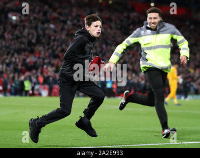 Eine junge pitch Eindringling versucht, Verwalter zu nach Erhalt der Shirt von Liverpools Andrew Robertson während der UEFA Champions League Gruppe E Match in Liverpool, Liverpool entziehen. Stockfoto