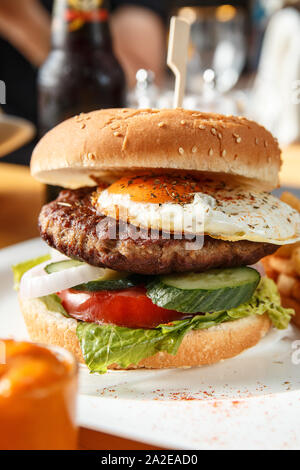 Burger mit Spiegelei und Pommes frites Nahaufnahme Stockfoto