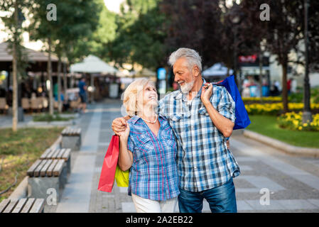 Gerne älteres Paar umarmt nach dem Einkaufen Stockfoto