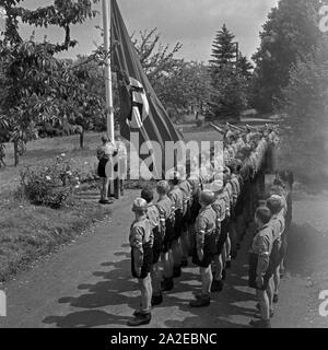 Morgendlicher Fahnenappell im Jungen Landjahr Lager in Bevensen in der Lüneburger Heide, Deutschland 1930er Jahre. Morgendliche flag Muster bei der Hitler Jugend Camp in Bevensen, Deutschland 1930. Stockfoto